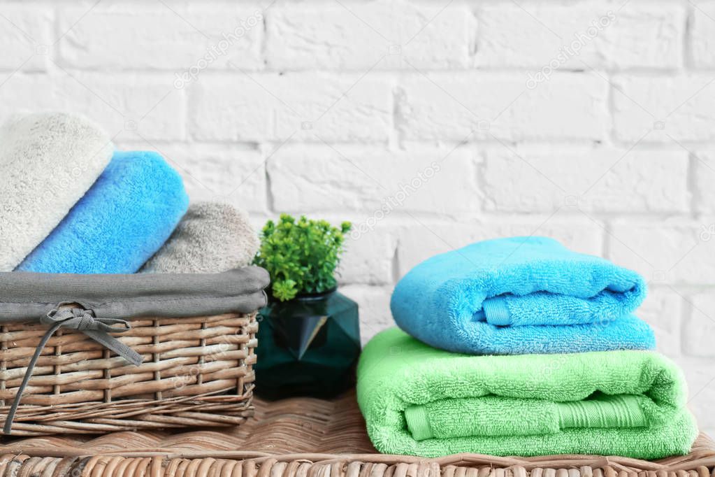 Colorful clean soft towels near brick wall