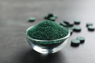 Spirulina yosun tozu hapları yakınındaki masada kase