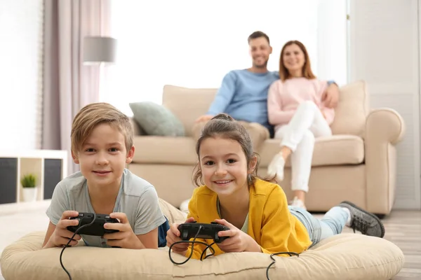 Söta Barn Spelar Spel Medan Föräldrar Vilar Soffan Hemma — Stockfoto