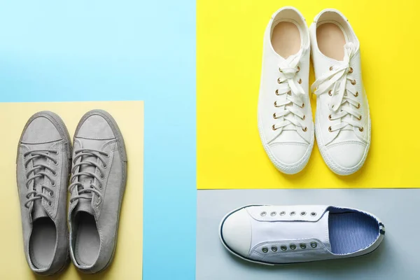 Flat lay composition with different sneakers on color background