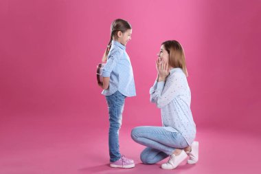 Mutlu anne ve kızı renk arka plan üzerinde hediye ile. Dünya Kadınlar günü