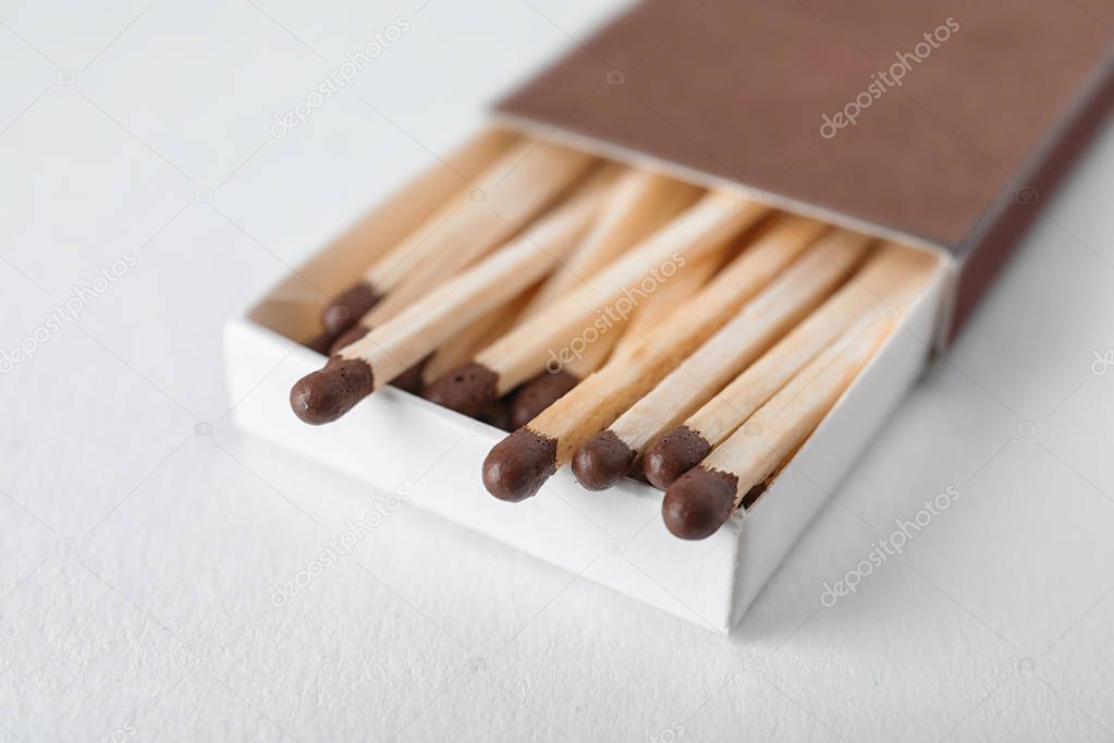 Cardboard box with matches on light background, closeup