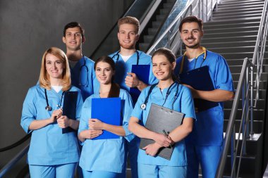 Tıp öğrencileri üniversite salonunda gülümseyen genç