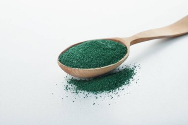 Spirulina yosun toz beyaz zemin üzerine kaşıkla