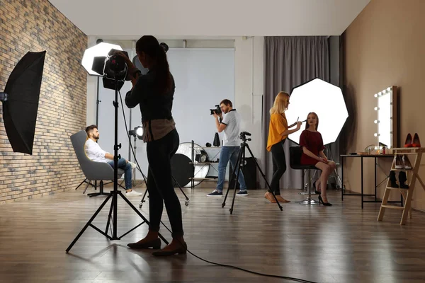 Photo studio with professional equipment and team of workers