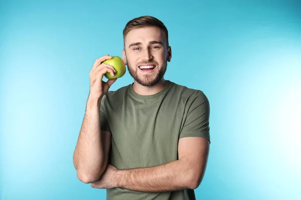 年轻人与健康的牙齿和苹果在颜色背景 — 图库照片