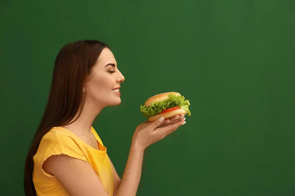 Jonge Vrouw Smakelijke Hamburger Eten Achtergrond Kleur Ruimte Voor Tekst — Stockfoto