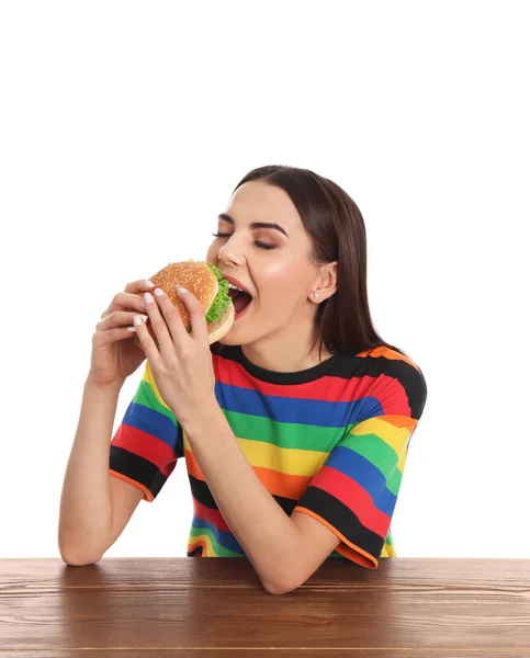 Jovem Mulher Comendo Hambúrguer Saboroso Mesa Fundo Branco — Fotografia de Stock