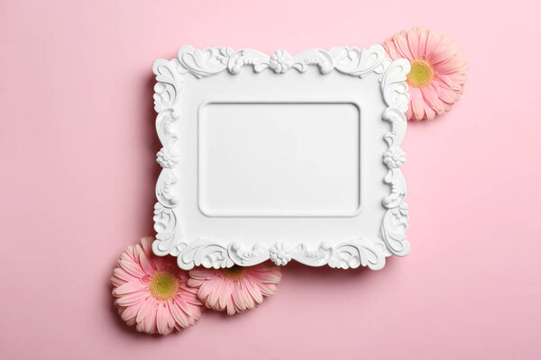 Empty photo frame and flowers on color background, top view. Space for text