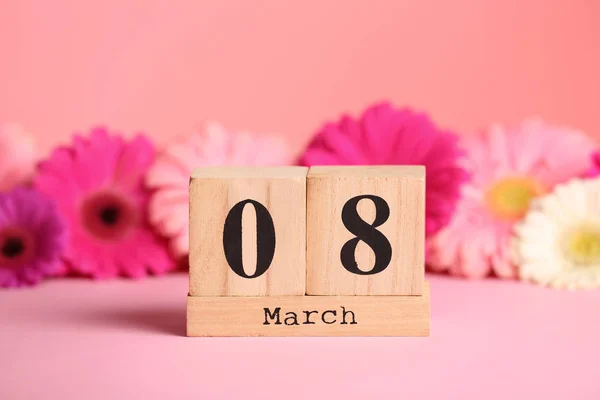 Holzblock Kalender Und Blumen Auf Dem Tisch Vor Farbigem Hintergrund — Stockfoto