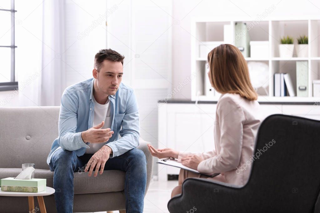 Psychotherapist working with young man in office