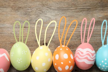 Renkli yumurta Paskalya tavşan kulaklı ahşap arka plan, üstten görünüm üzerinde kümesi