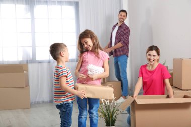 Mutlu bir aile yeni evlerinde kutuları açma. Taşınma günü
