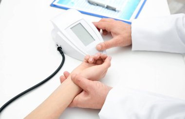 Genç kadının nabız kontrol ve hastane, closeup masada kan basıncı ölçme doktor