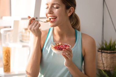 Sağlıklı kahvaltı evde olan fitness giysili genç kadın