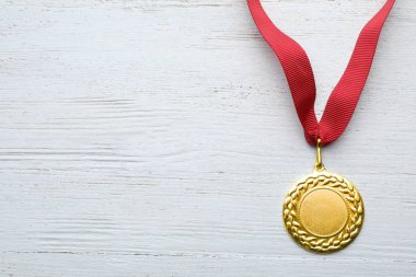 Beyaz ahşap arka plan, üstten görünüm tasarımı için alan ile altın madalya. Zafer kavramı