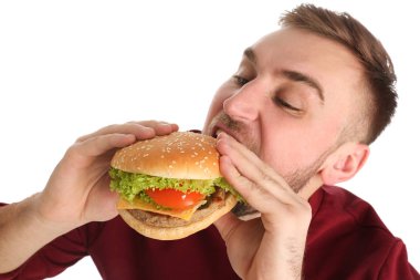 Genç adam beyaz zemin üzerine lezzetli hamburger yeme