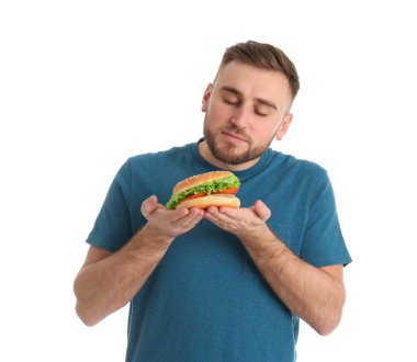 Beyaz zemin üzerine lezzetli hamburger ile genç adam