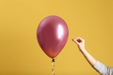 Kadın renk arka plan, closeup iğne ile balon piercing