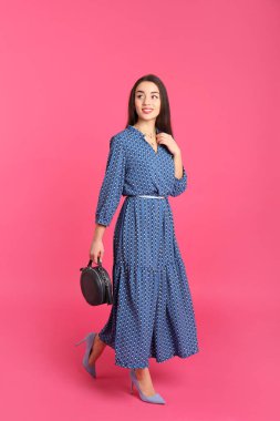 Renk arka plan üzerinde şık elbiseli güzel genç kadın portresi