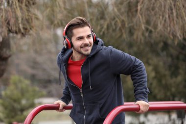Müzik ve spor zemin üzerinde egzersiz kulaklık ile genç adam