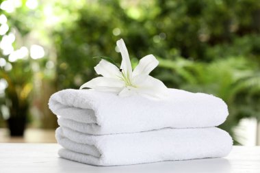 Temiz yumuşak havlu ve çiçek tablo arka plan bulanık karşı yığını