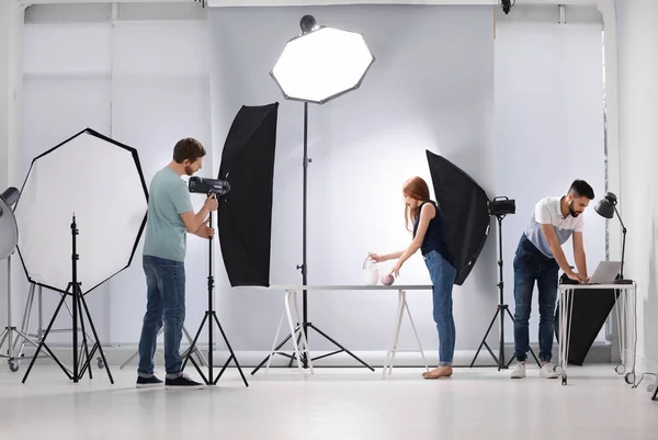 Photo studio with professional equipment and team of workers