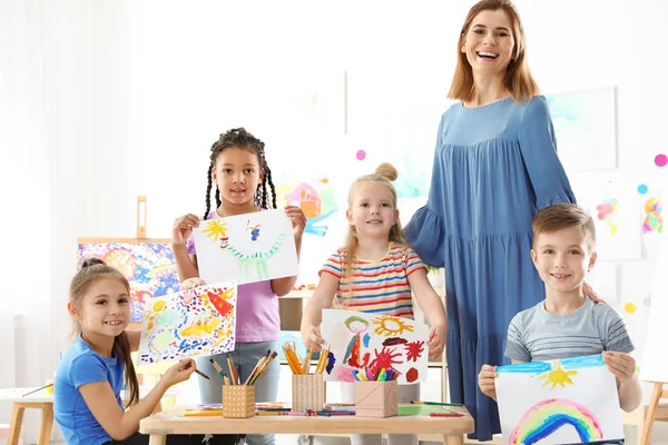 Söta Lilla Barn Med Lärare Visar Sina Målningar Lektion Inomhus — Stockfoto