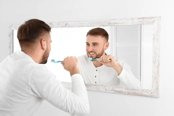 Молодой Человек Чистит Зубы Перед Зеркалом Ванной Комнате — стоковое фото