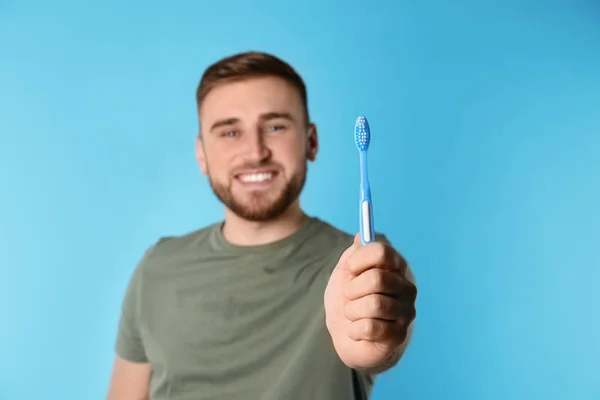 Junger Mann Mit Bürste Und Zahnpasta Auf Farbigem Hintergrund Platz — Stockfoto