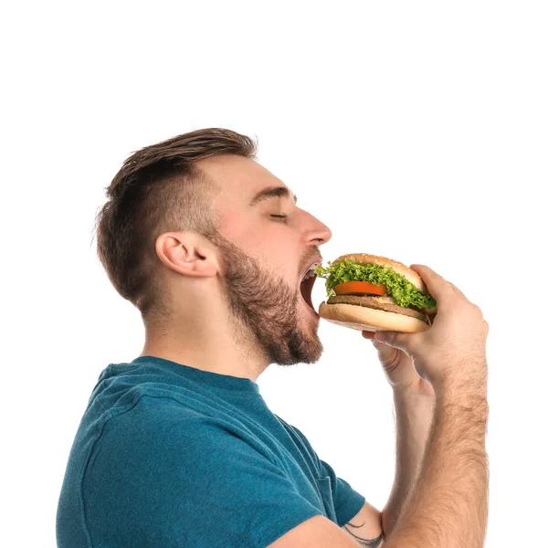 Jonge Man Eten Smakelijke Hamburger Witte Achtergrond — Stockfoto