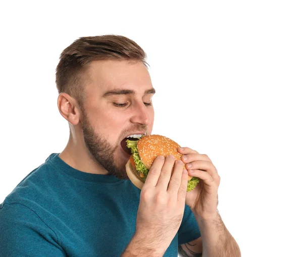 Jonge Man Eten Smakelijke Hamburger Witte Achtergrond — Stockfoto