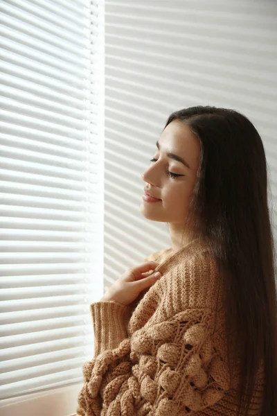 Mujer Joven Cerca Ventana Con Persianas Venecianas —  Fotos de Stock