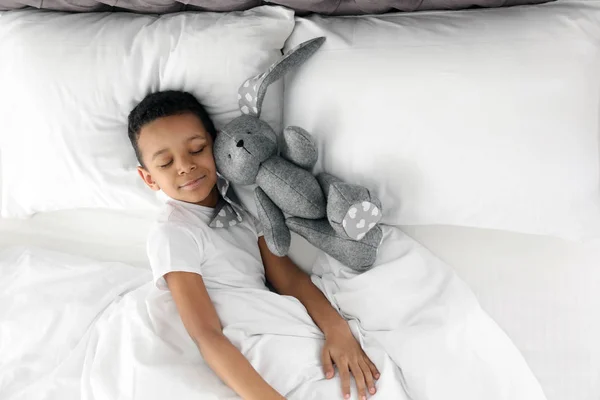 Carino Piccolo Afro Americano Ragazzo Con Giocattolo Coniglio Dormire Letto — Foto Stock