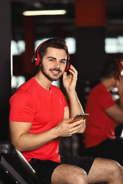 Hombre Joven Con Auriculares Escuchando Música Dispositivo Móvil Gimnasio — Foto de Stock