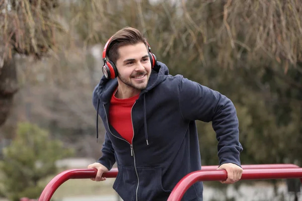 Jeune Homme Avec Casque Écoutant Musique Faisant Exercice Sur Terrain — Photo