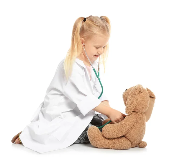 可爱的孩子想象自己是医生 而玩听诊器和玩具兔子在白色的背景 图库照片