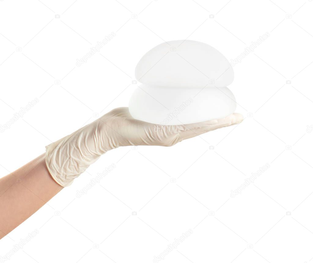 Doctor holding silicone implants for breast augmentation on white background. Cosmetic surgery