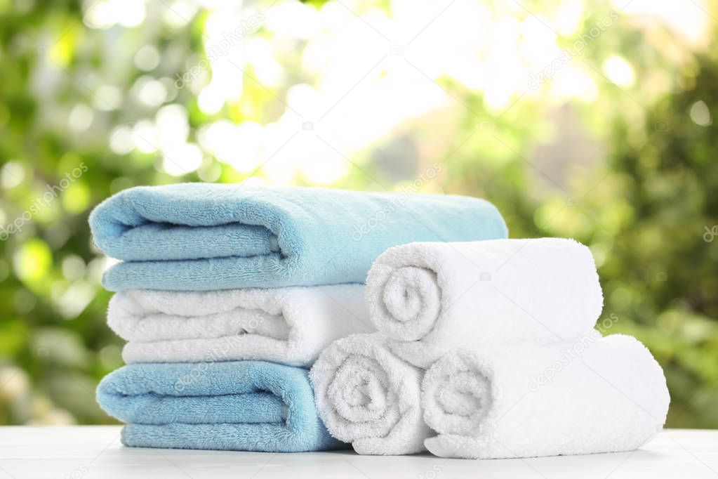 Soft bath towels on table against blurred background