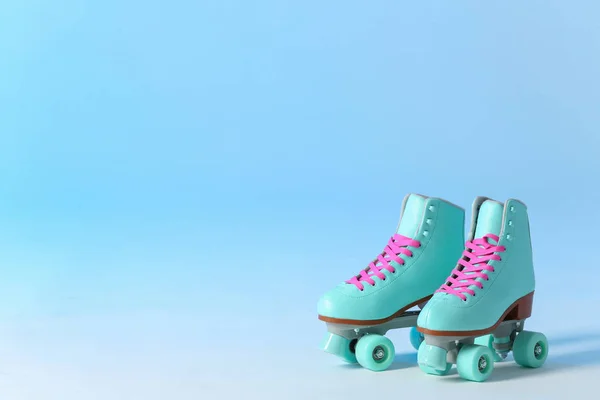 Pair of vintage roller skates on color background. Space for text