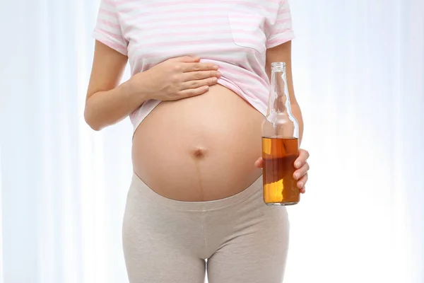 Kobieta Ciąży Butelką Whisky Jasnym Tle Uzależnienia Alkoholu — Zdjęcie stockowe