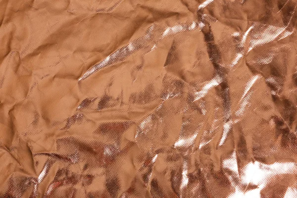 Crumpled rose gold foil as background, closeup view