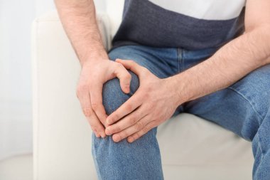 Genç adam bacak ağrısı kapalı, closeup acı