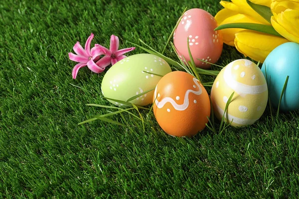 五颜六色的彩绘复活节彩蛋和绿色草地上的花 文字空间 — 图库照片
