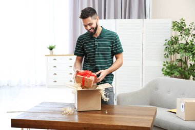 Genç adam açılış parsel masada evde