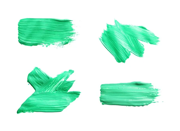 Set with abstract brushstrokes of green paint on white background, top view — Stock Photo, Image