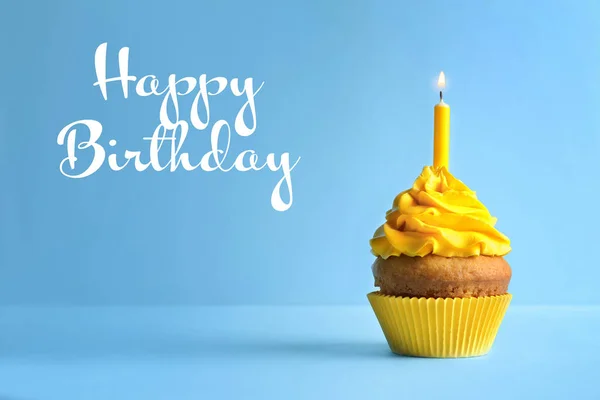 Heerlijke cupcake met kaars en tekst Happy Birthday op blauwe achtergrond — Stockfoto