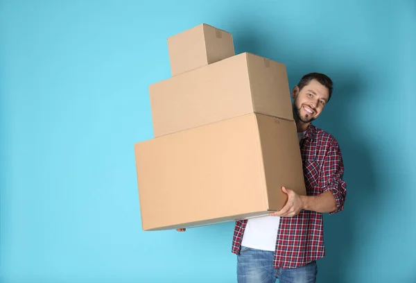 Hombre con cajas móviles sobre fondo de color. Espacio para texto — Foto de Stock