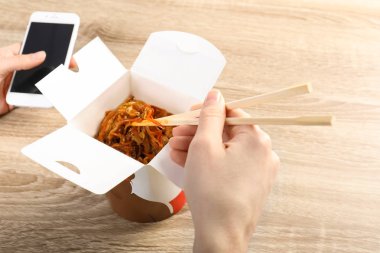 Ahşap masa, closeup Çin noodle yemek kadın. Food teslim