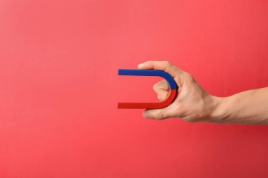 Renk arka planda, closeup mıknatıs tutan adam. Metin için yer